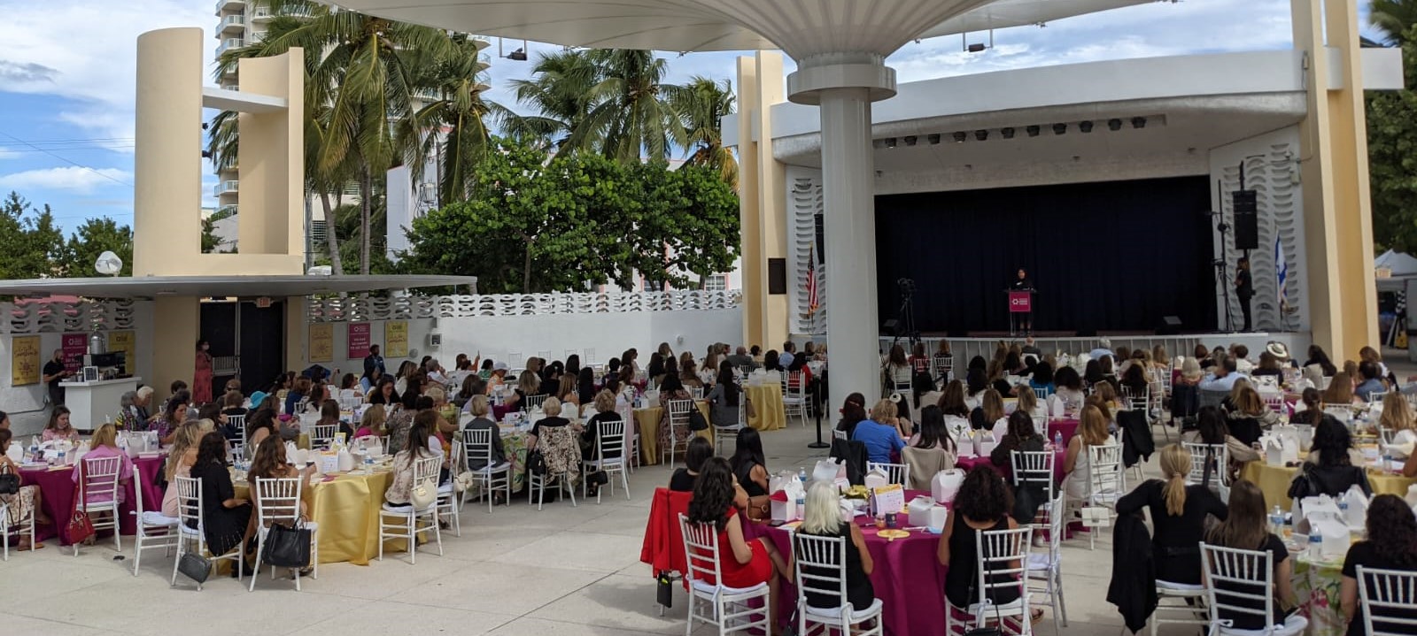 Outdoors stage and women sitting at tables